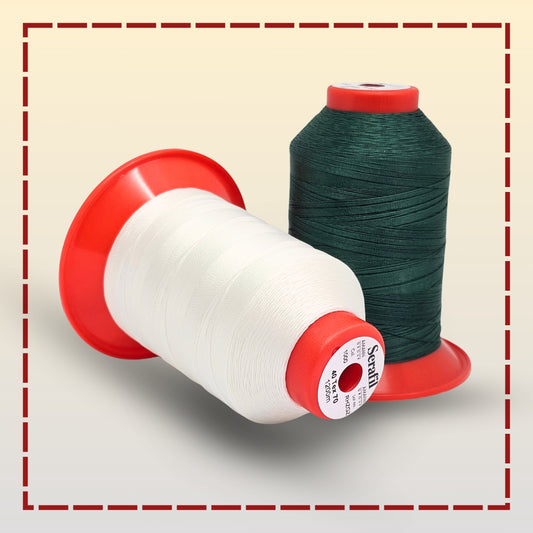 Two spools of thread, one white and one green, on a light gray background.